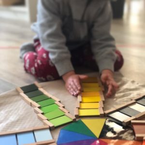 Un enfant range des tablettes par couleur